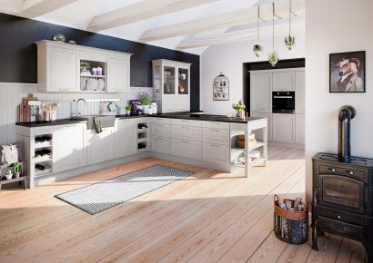 Häcker Landhausküche in Creme mit Rahmenfronten, dunkler Arbeitsplatte und offenen Regalen, gemütliche Küche mit Holzdetails und klassischem Charme