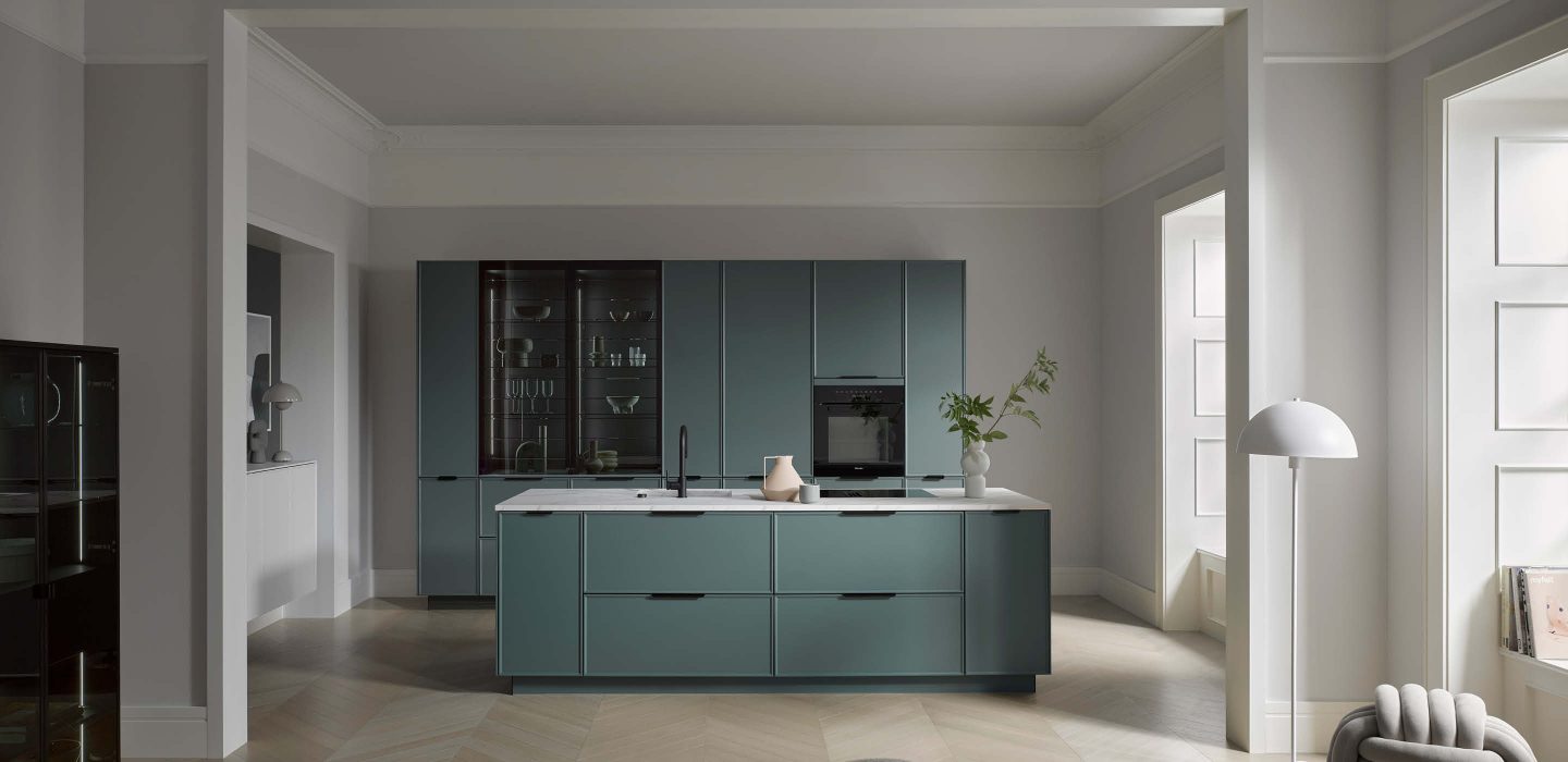 Moderne Häcker Küche in Grün mit Kücheninsel und grifflosem Design, integrierte Geräte und klare Linien, elegante Wohnküche mit minimalistischer Optik