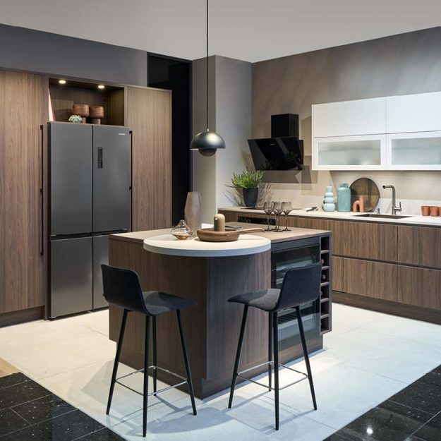 Moderne Häcker Designküche in Schwarz mit Kochinsel und integrierter Spüle, minimalistische Gestaltung mit dunklen Fronten und eleganter Beleuchtung